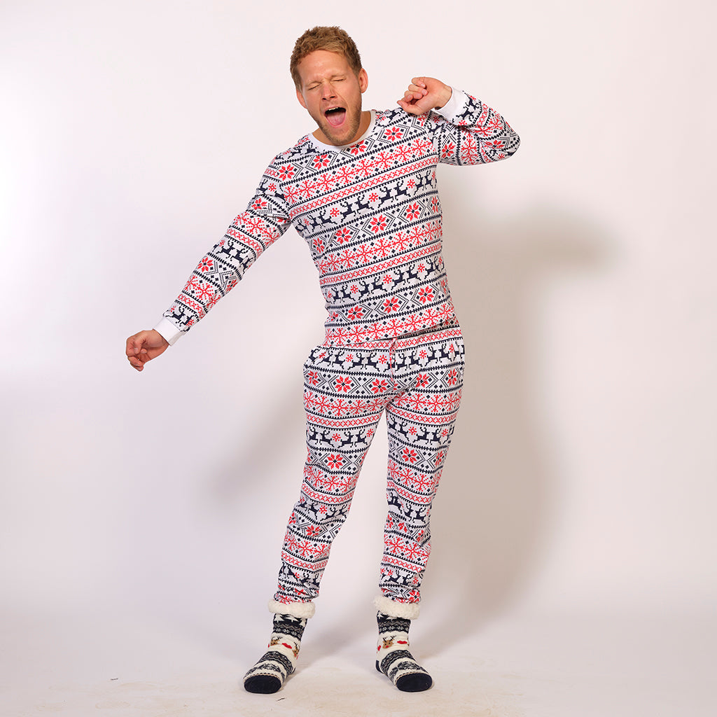 En gabende mand iført hvide julepyjamas med julemønster.